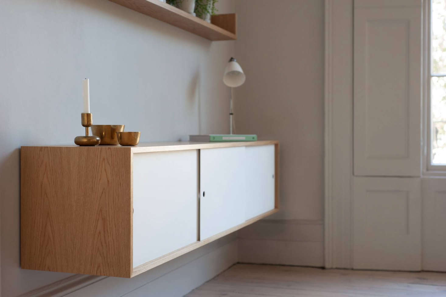 Next to the dining table is a Cantilevered Sideboard from Jack Trench, made of matching white oak with Corian sliding doors.