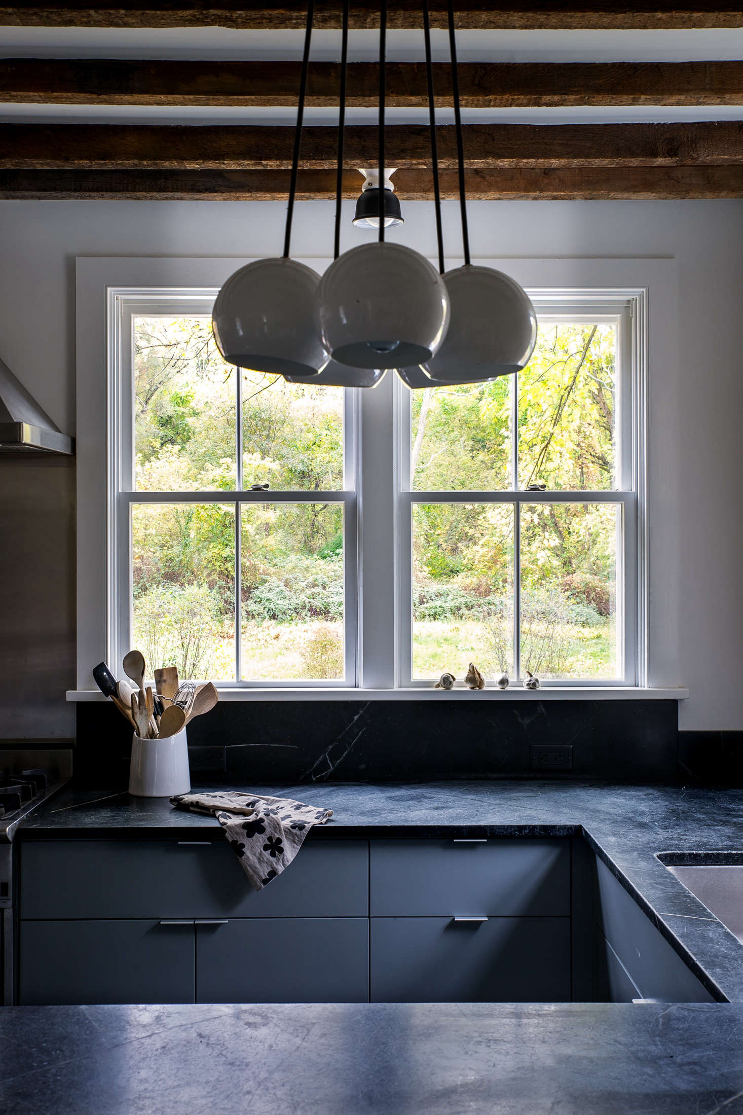 Dunja also removed a central island in favor of a U-shaped counter layout. (The tea towel on the countertop was designed by Dunja. Visit her her online shop, Doonyaya, for similar.) A cluster chandelier from Schoolhouse Electric illuminates the breakfast bar.