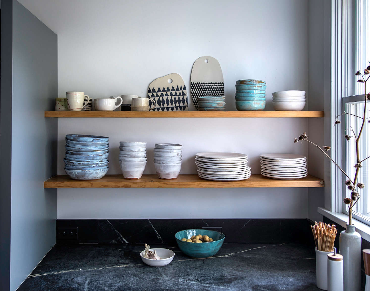 Open shelving holds Dunja’s collection of dishes by Tivoli Tile Works. The geometric cheese boards are by Dunja (left) and Mbartstudios (right).
