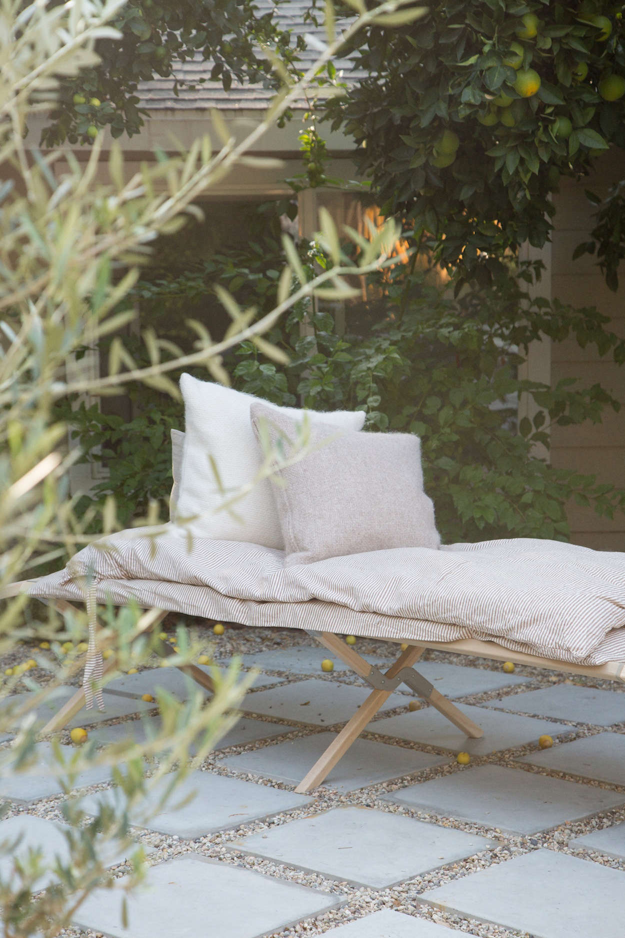 When they bought the house, says Hunter, the outdoor space “was filled with AstroTurf and bougainvillea.” Now, the yard has citrus trees and an informal patio of concrete pavers and gravel. On the daybed, with the alpaca pillows: A Striped Linen Duvet (a collaboration between Jenni Kayne and Parachute); $349 for full/queen duvet with two shams.