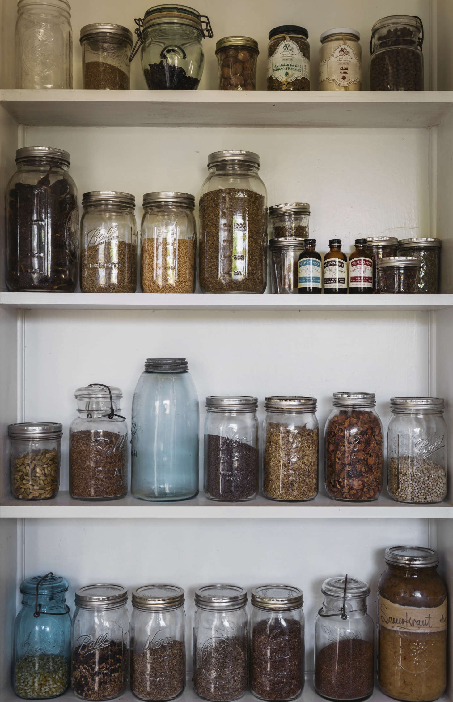 A pantry shelf behind the sink holds dried herbs, spices, grains, nuts, and even house-made sauerkraut.