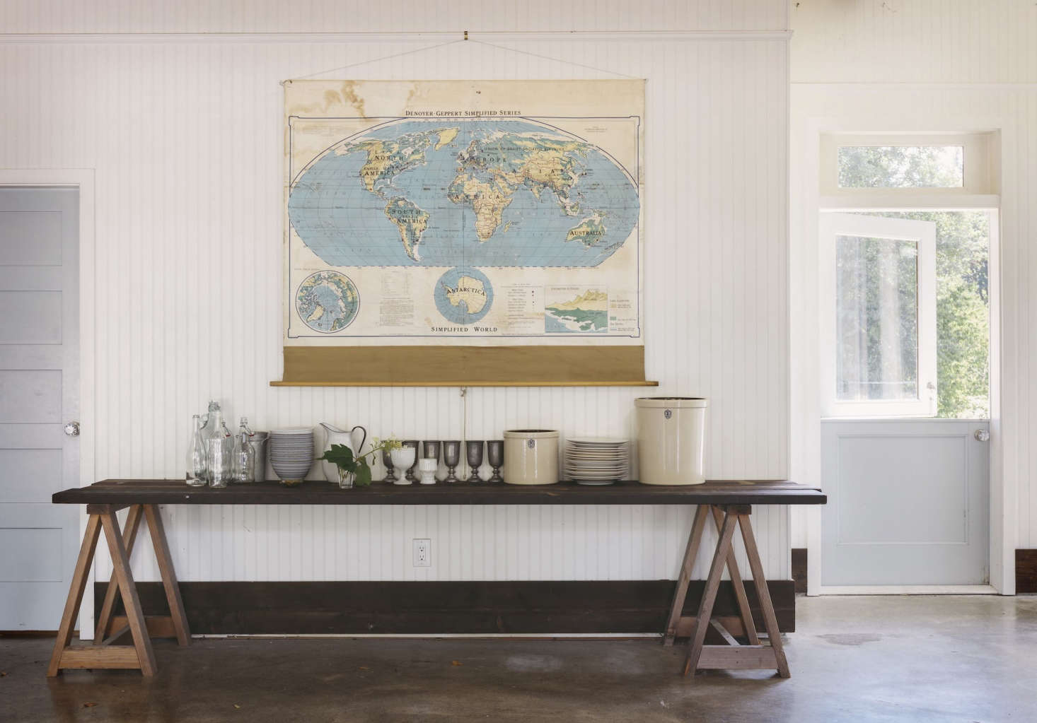 A trestle table in the cookhouse holds pewter cups, porcelain bowls, and farmhouse crocks at the ready for events.