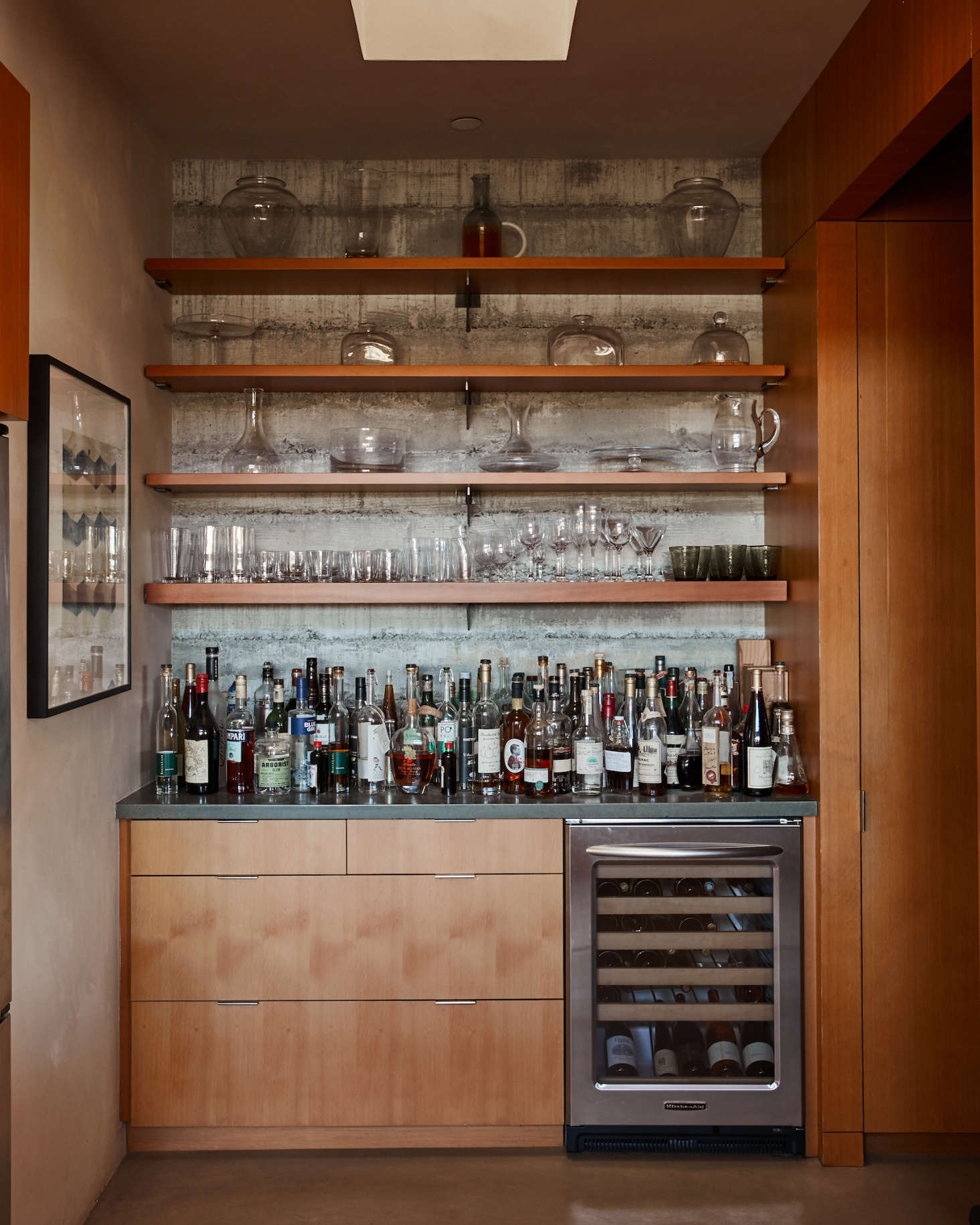 An amply stocked liquor cabinet and under-counter fridge (filled with Baker Lane wines) marks the entrance to the walk-in pantry. Floors throughout the house are concrete with an integrated pigment.