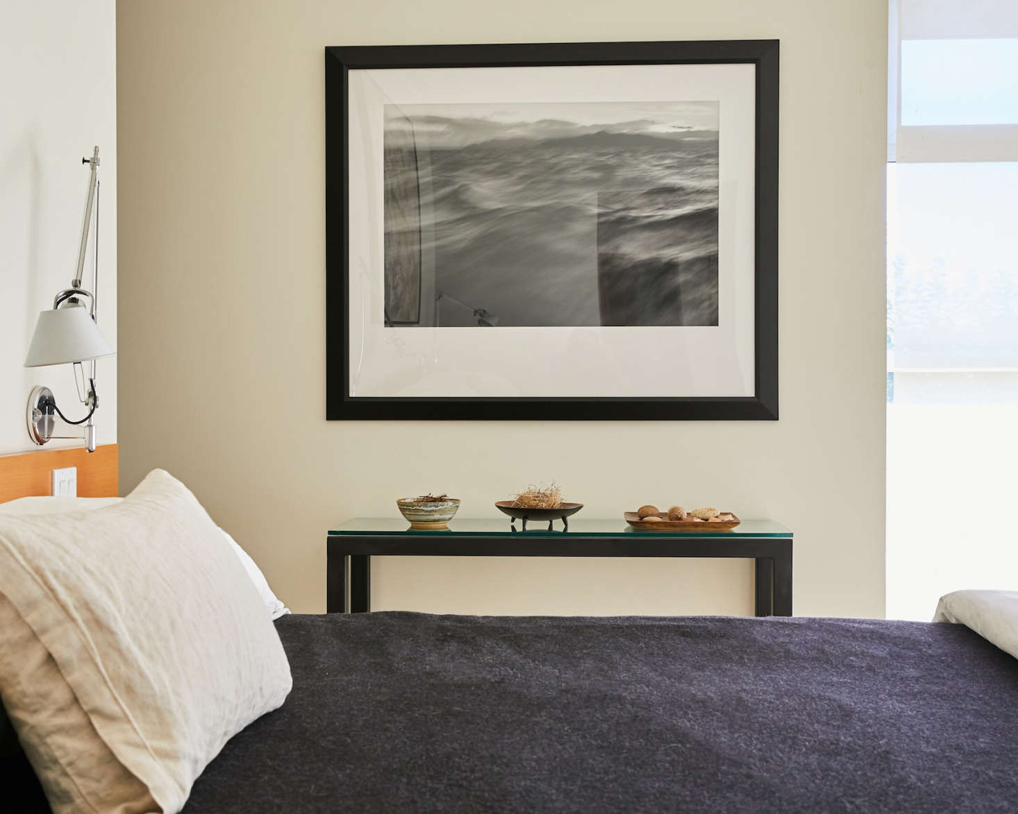 Next to the bed: A glass-topped credenza with displays of natural objects collected by Boynton, beneath a photograph by Charles Richardson.
