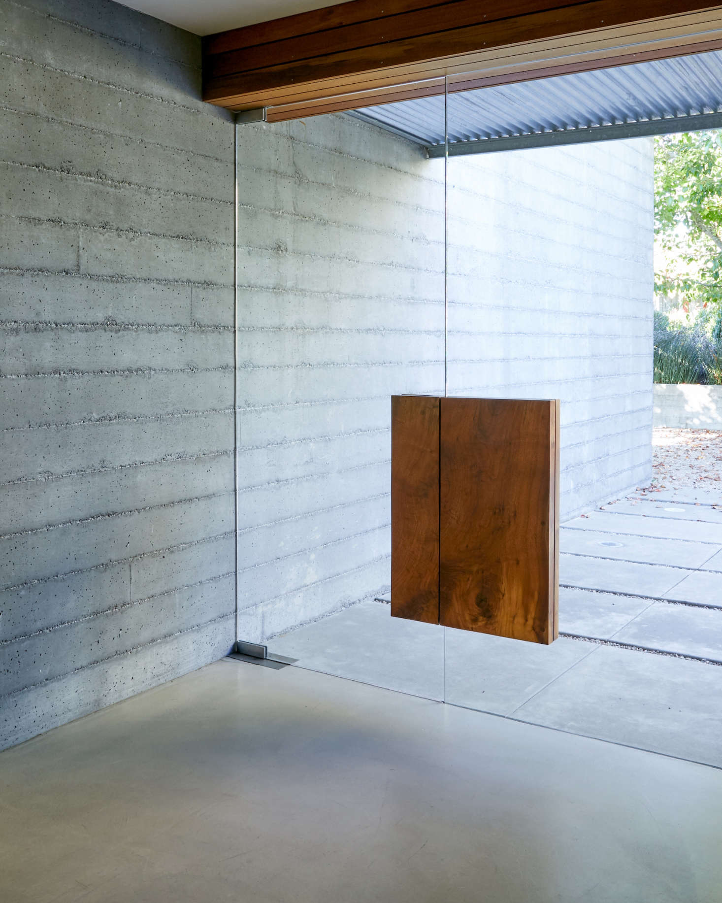 The front door is made of two glass panels, each with a block of claro walnut wood 
