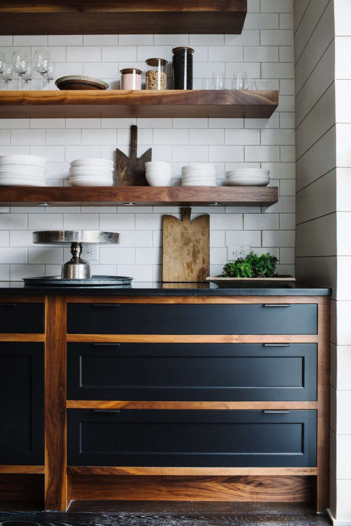 Floating shelves made of solid walnut hang over custom oiled walnut cabinets with painted maple fronts and steel handles.