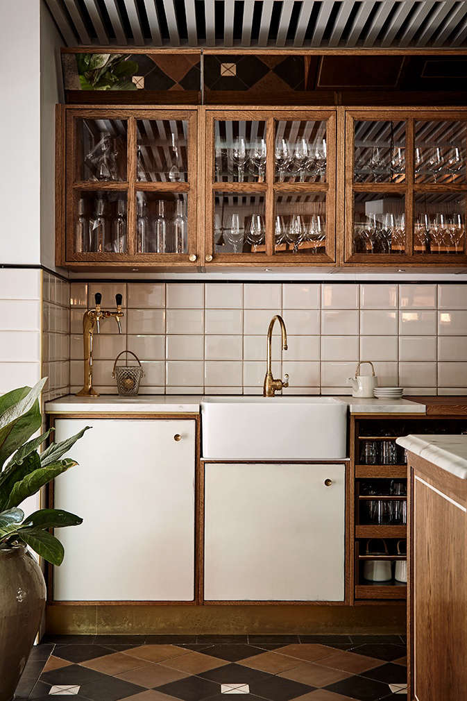 Glassware stocked behind the bar, and a backsplash of oversized white tile.