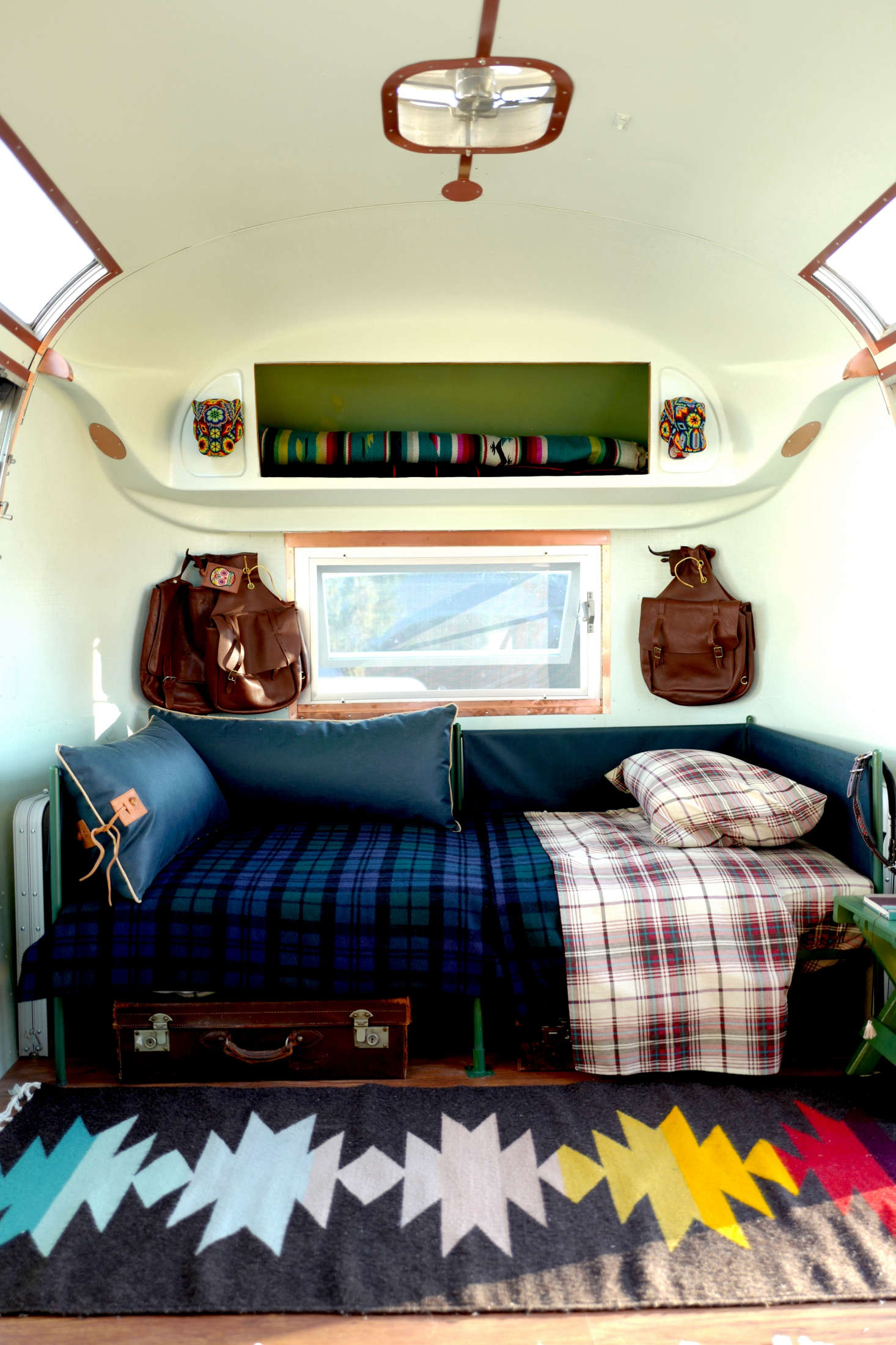 The sofas easily transform into twin beds. Coleman folding picnic tables are slotted on the sides, and underneath, vintage English leather suitcases (found in San Miguel) hold essentials from shoes to dishes—”they’re super practical, and nicer looking than rolling boxes,” Jorge says. “And I like the look; I didn’t want everything to be built-in.”