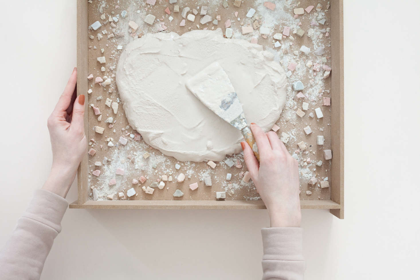 The mixture is poured like cake batter into the frame and then evenly troweled. The tricky part is smoothing out the concrete without displacing the tile fragments.