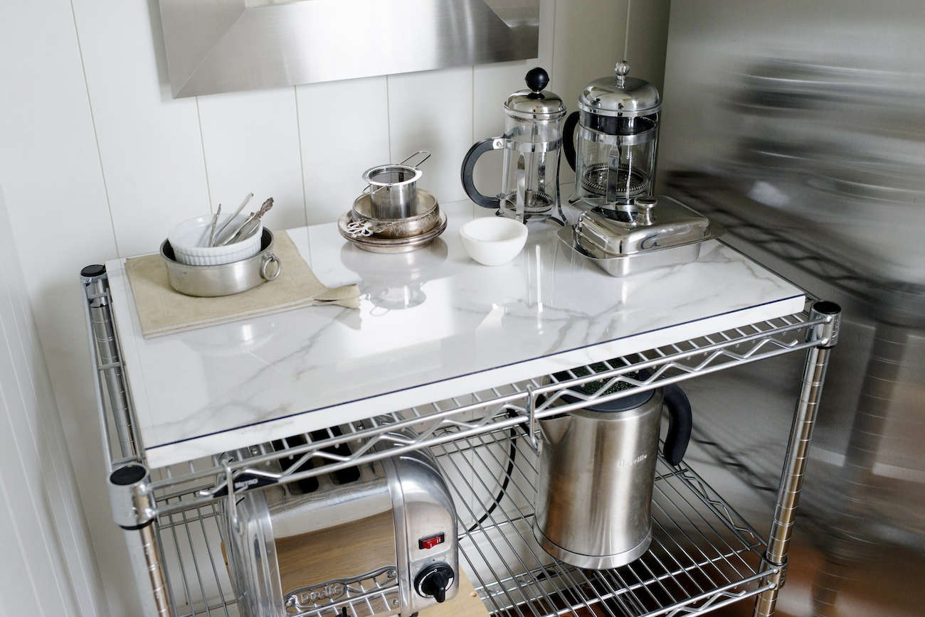 Architect Barbara Chambers topped a metal slatted shelf in her kitchen with a small piece of marble to create a functional surface, which she uses as a coffee and tea station. See the rest of her house at An Exercise in Order with Architect Barbara Chambers.