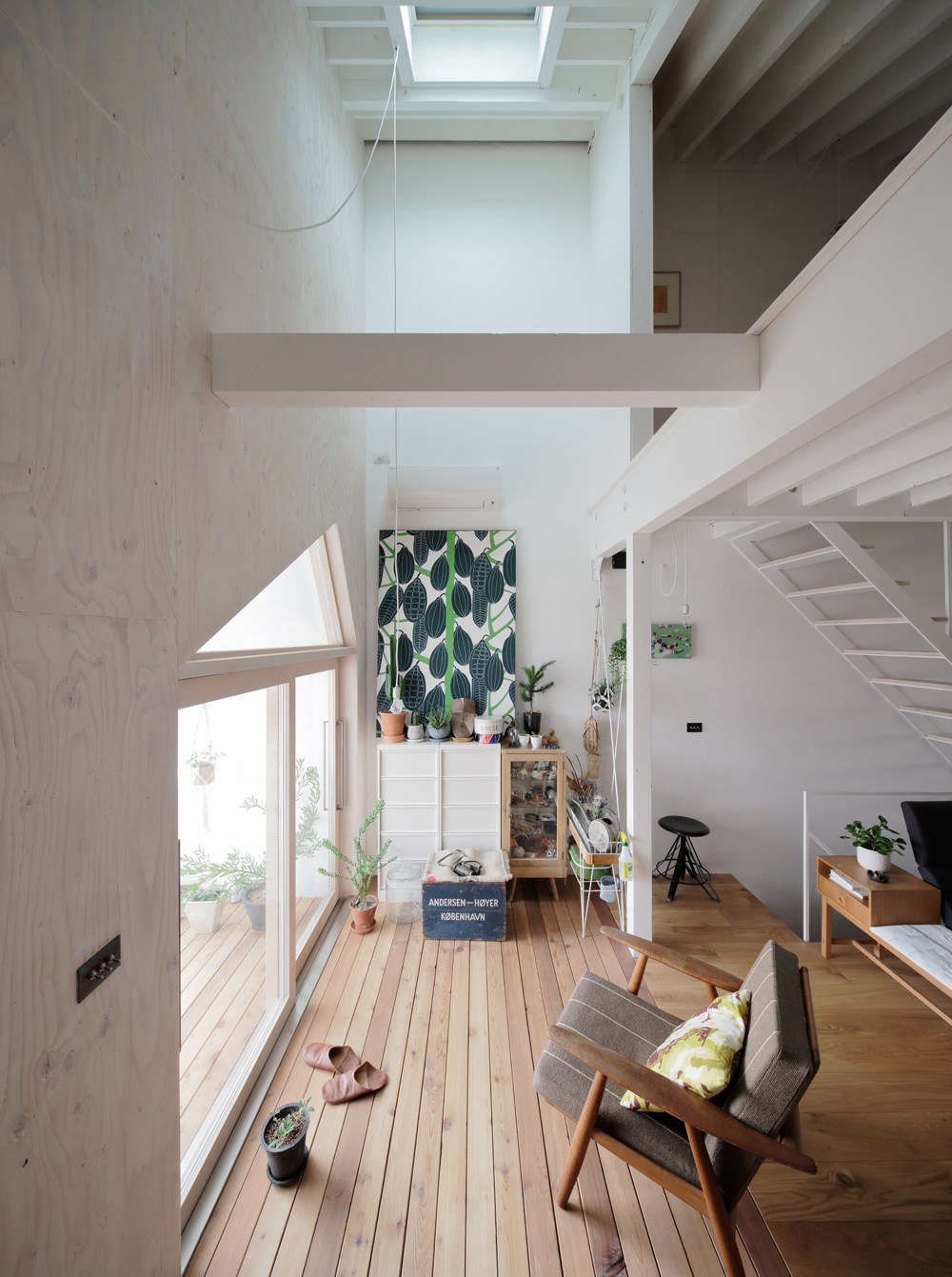 The living area is oriented to the front, south-facing balcony and brightened by a skylight. That’s the bedroom overhead.