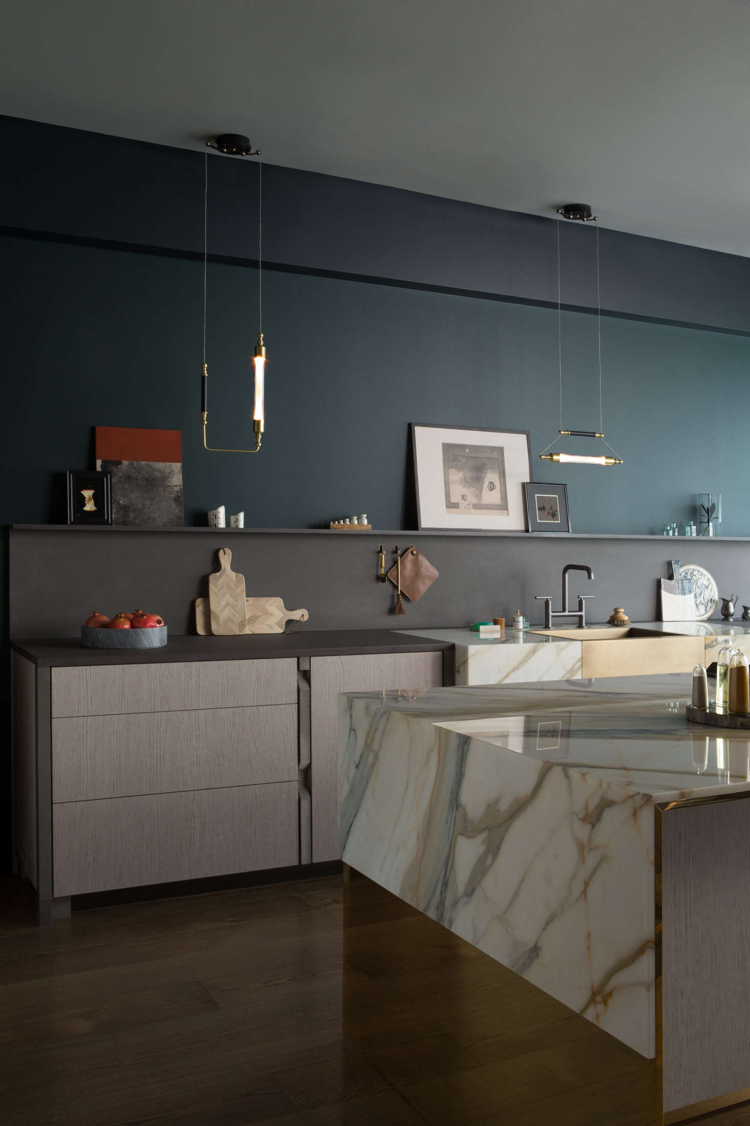 Black walnut cabinets flank a butler’s sink of brushed brass framed by Calacatta Borghini marble.