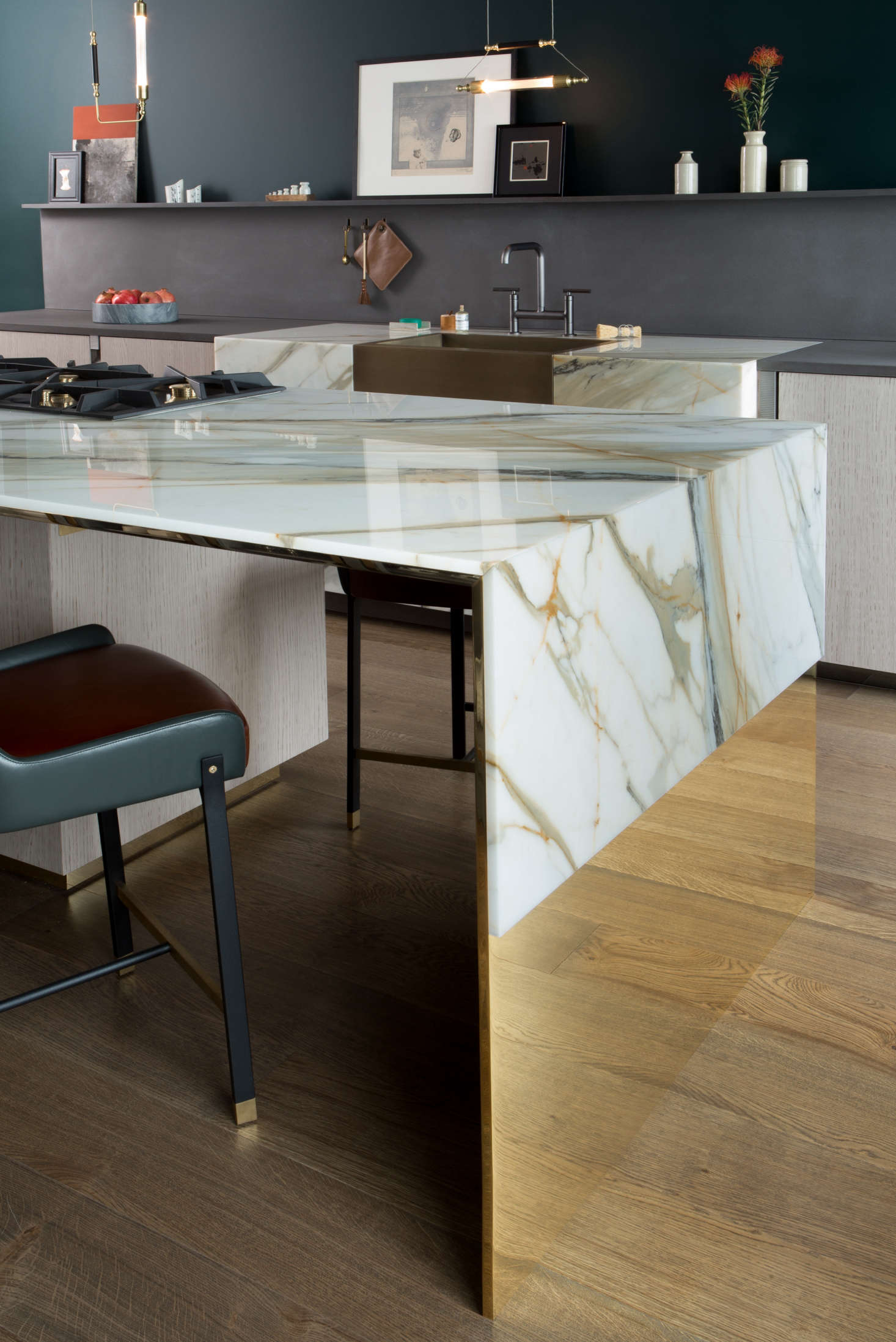 Calacatta Borghini marble is “draped” atop the polished brass island, so that the richly veined stone looks like a luxe version of humble oilcloth.