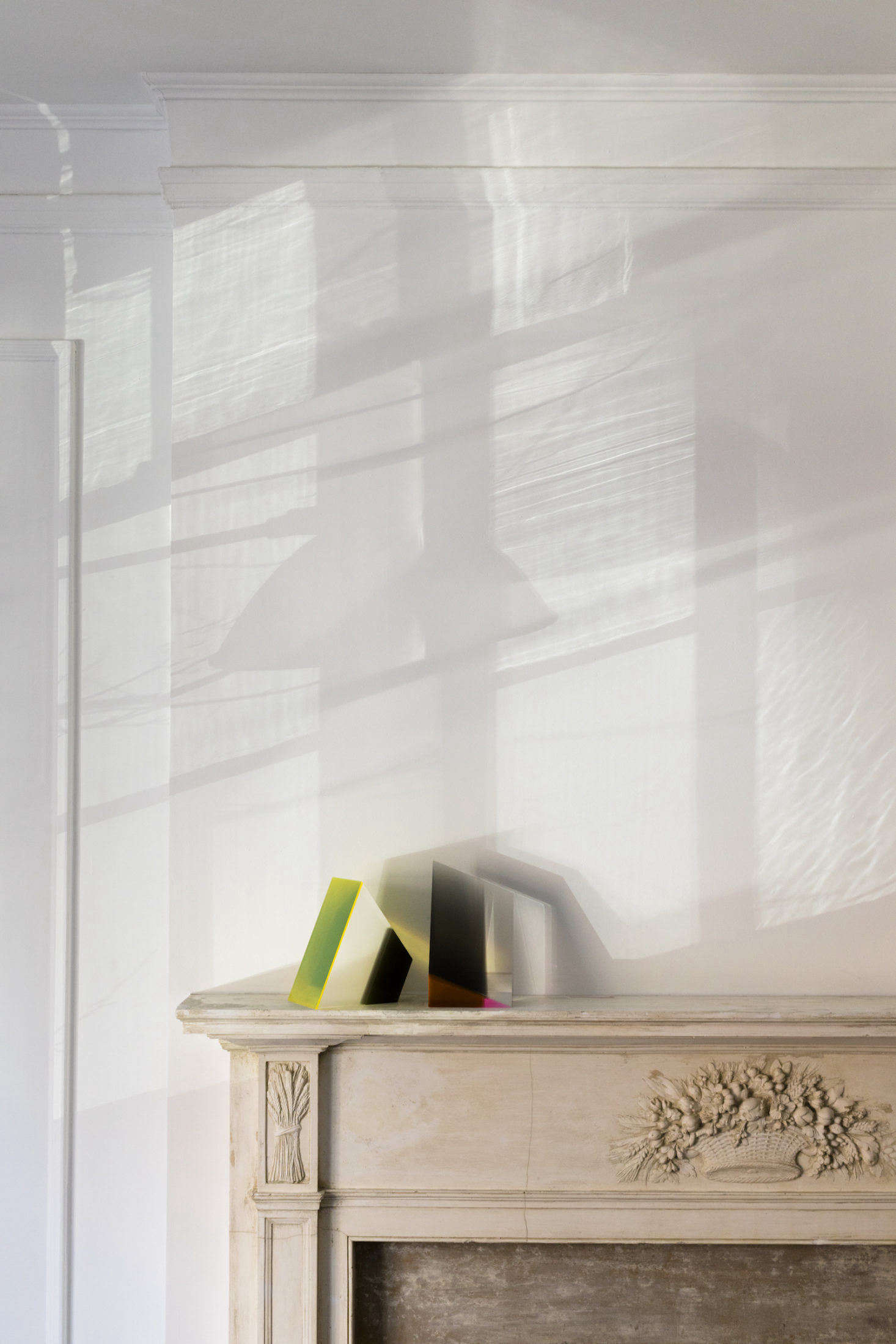 The couple had the original wood fireplace mantel stripped for a more modern look. Resting on it are one-of-a-kind acrylic sculptures, their anniversary presents to each other, by NYC-based artist Phillip Low.