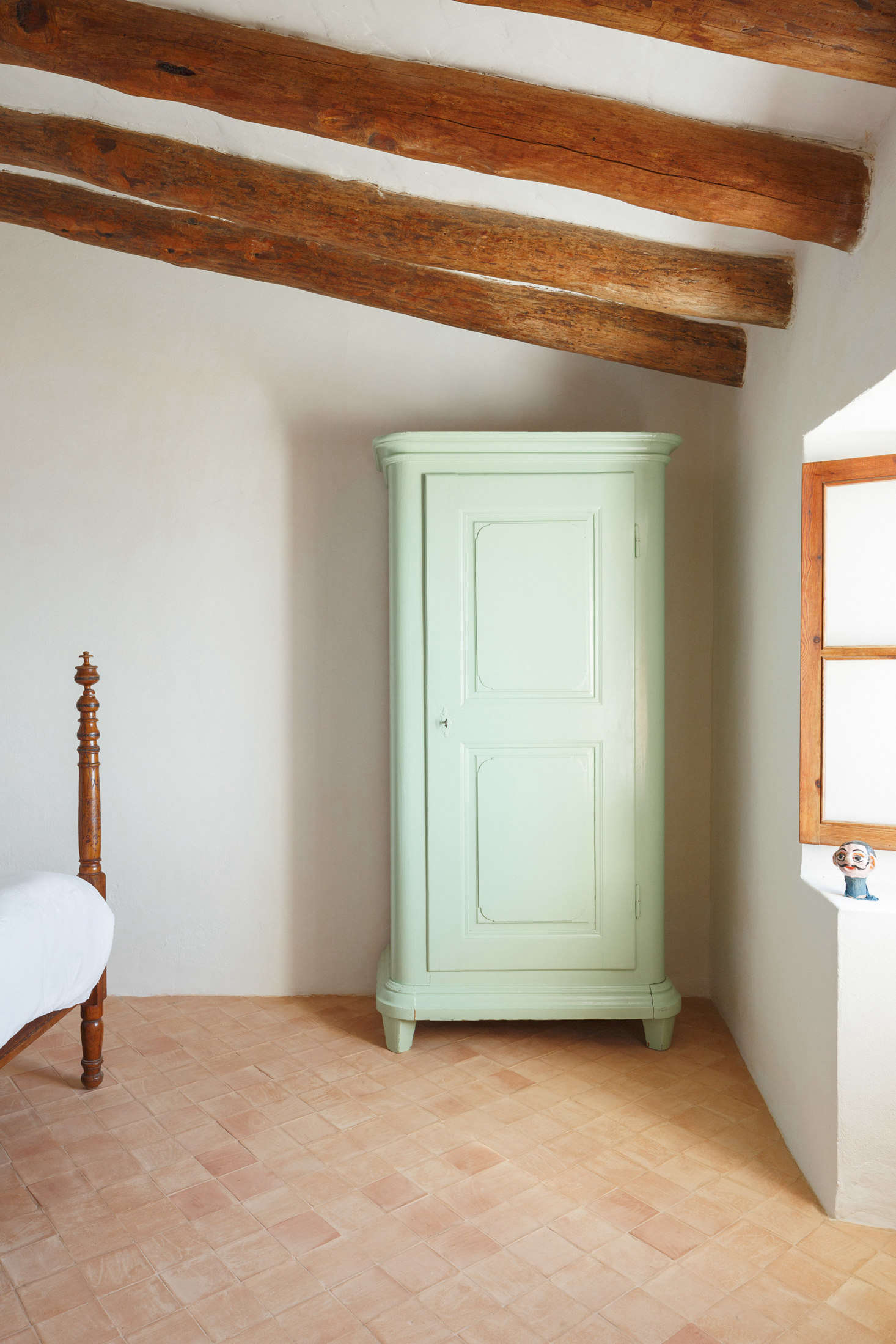 At the foot of another bed: “a green armoire, bought as-is in a brocki in Basel.”