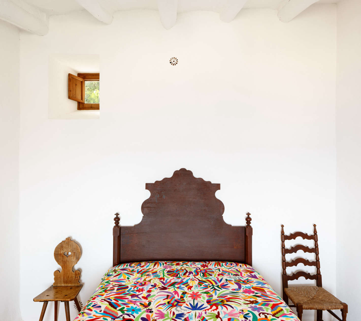 The architects added small windows in the back of the house for cross-ventilation. The small floral vent above the bed is a crucial addition: “The house is placed between terraces, so half of the house is sunken and in direct contact with the terrain,” the architects say. The clay ventilation system, placed between the house’s inner and outer walls, keeps the inner walls dry. The architects also treated the walls on the back of the house with a “highly-breathable mortar” by Keim.
