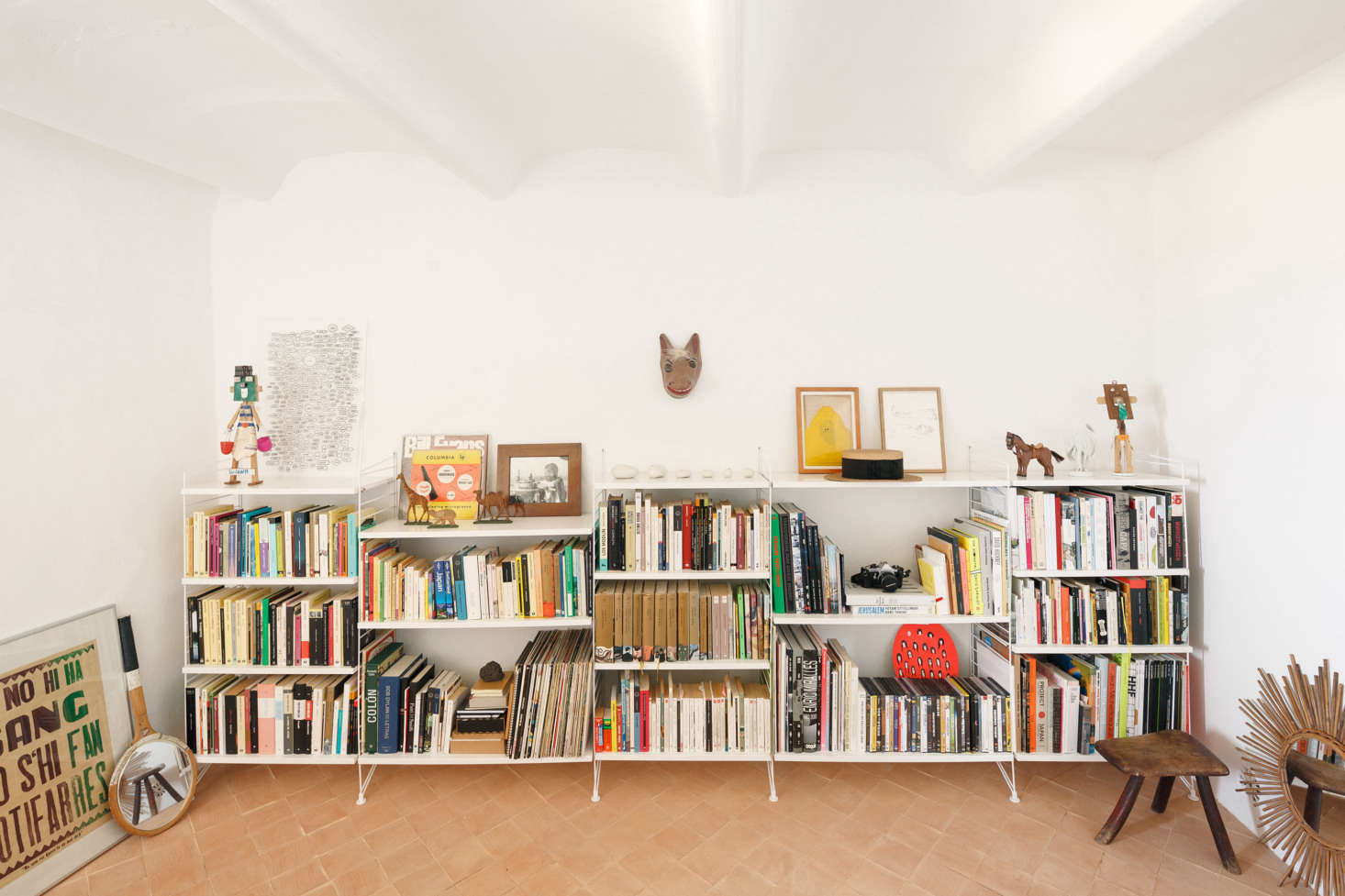 The library has the most lived-in look, with books and finds stashed on low white shelves. Palencia and Colón replaced the existing colored cement tiles with handmade terracotta square tiles “placed at a 45 degree angle, and treated as raw as possible,” they say.