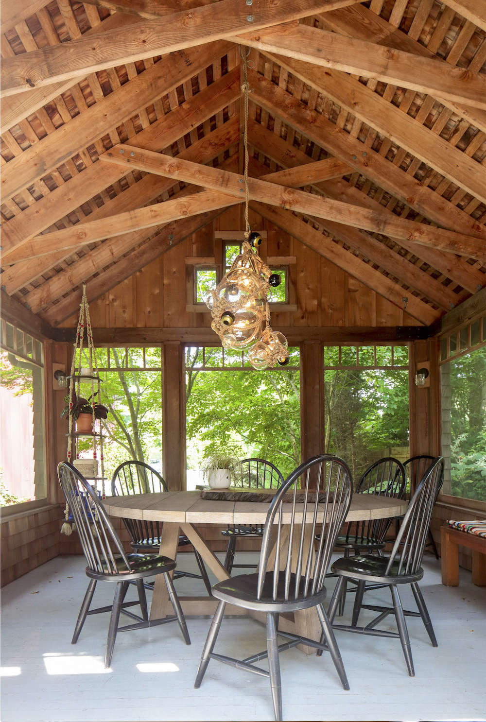 A Knotty Bubbles chandelier by Lindsey Adelman hangs above the round dining table in the screened porch.
