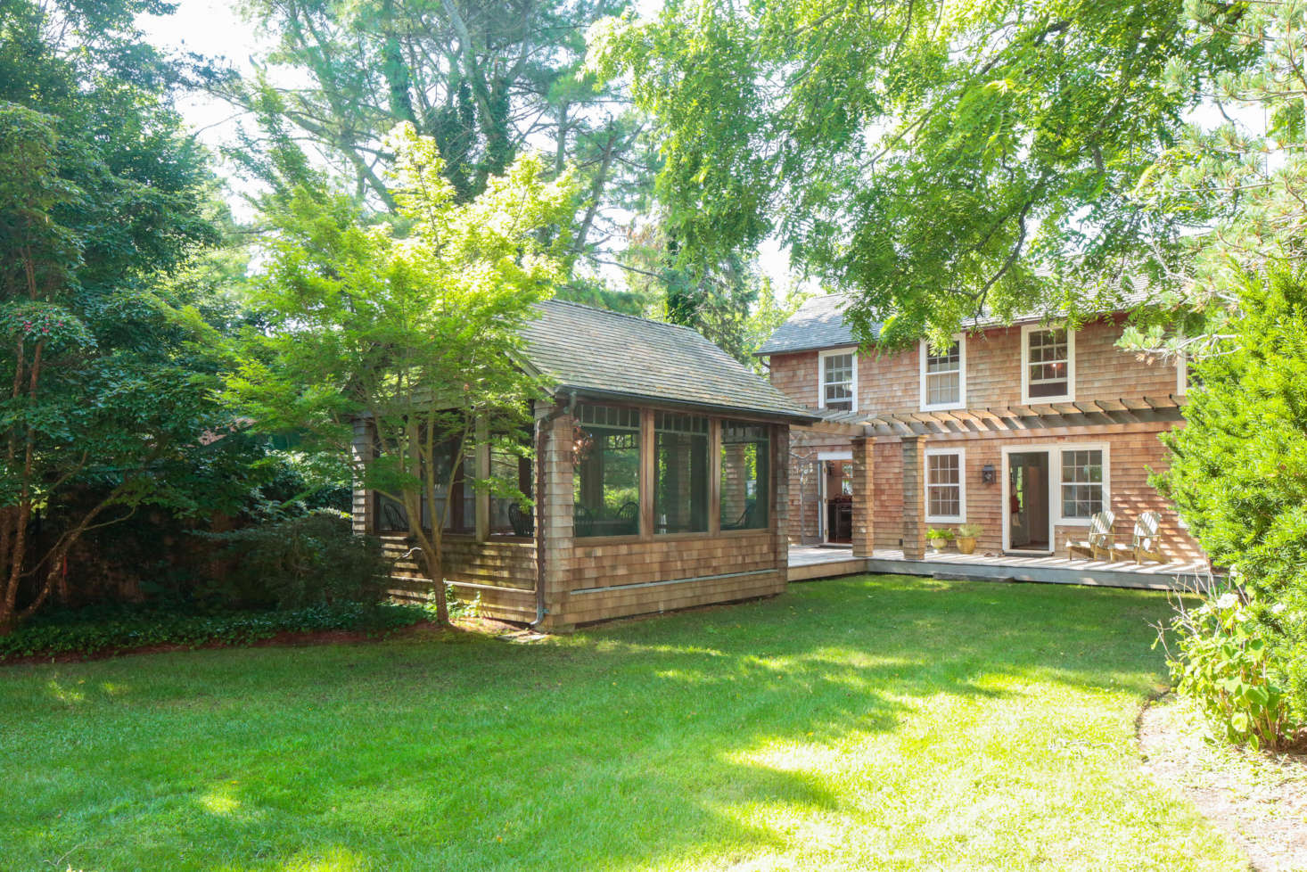 The cedar shingle-clad house dates from 1850; the screened dining porch at left was added later.