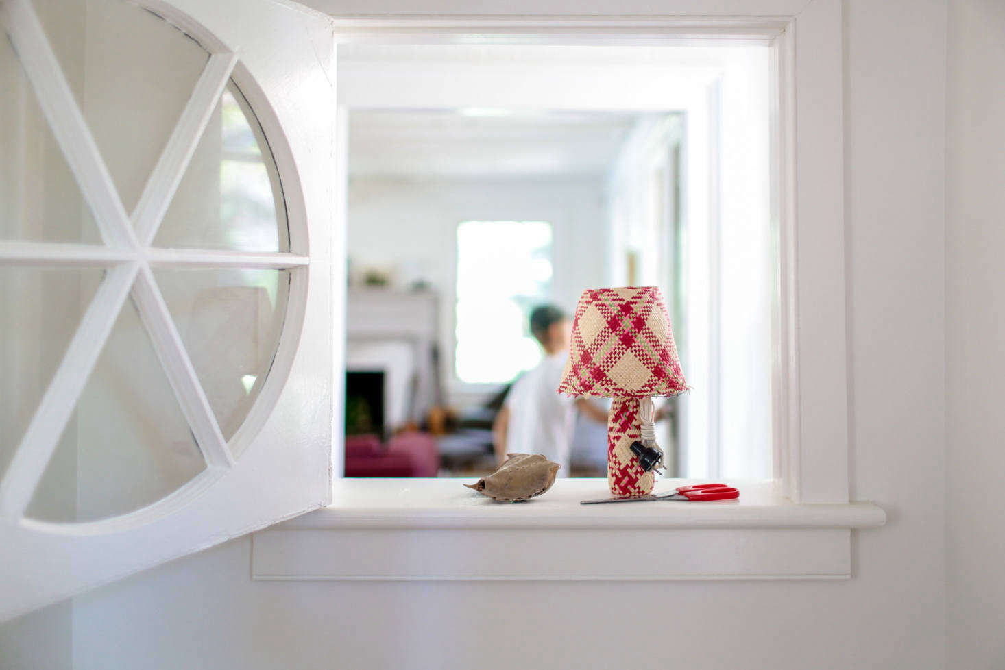 An original interior window looks into the living room from the kitchen.