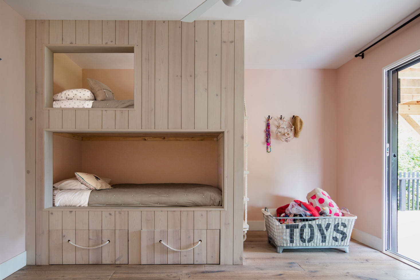 The kids’ room has a built-in, floor-to-ceiling pine wood bunk bed with storage drawers beneath. The walls are painted in Pink Ground from Farrow & Ball. Part of the owners’ desire for a home in Montauk, explained the architect, was to give their daughters “a laid-back escape; a place more similar to where they both grew up in Ireland.”