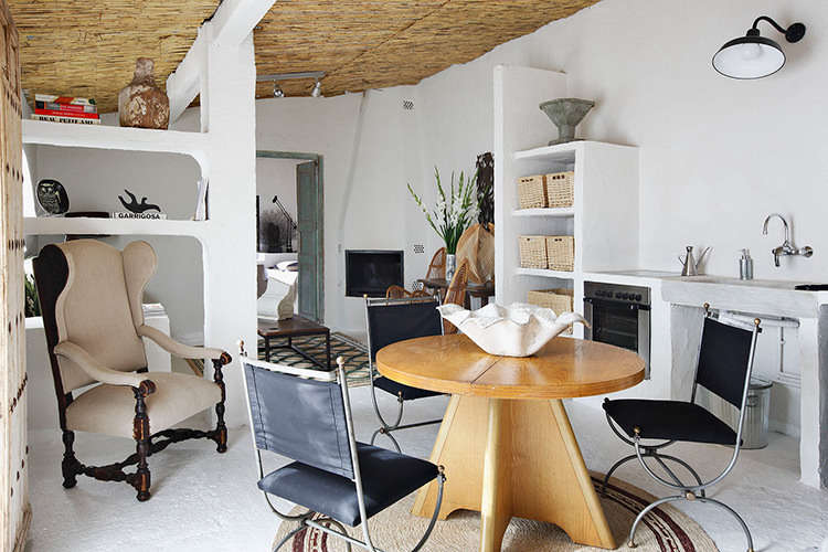 The sculptural main room of the guest house, loosely divided by built-in shelves that extend from the walls. Castella wanted to transform the “shell” of a stable into “a memorable, Mediterranean environment,” someplace that would “make you feel that you were on vacation on the sea.” Castella also took cues from his own childhood summers spent on the Costa Brava with his grandparents.