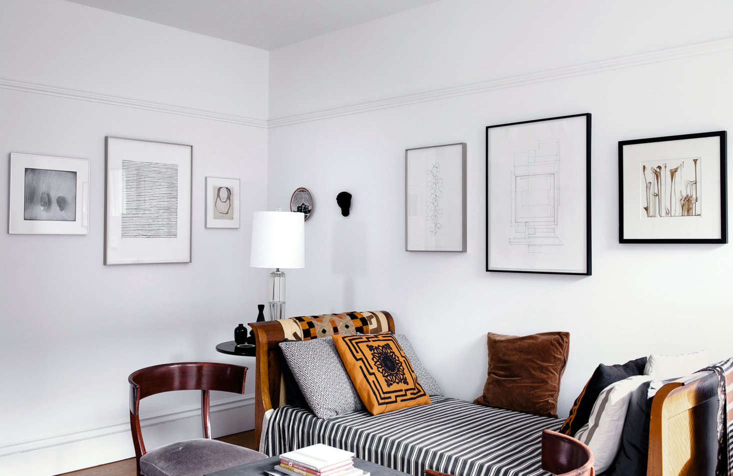 The sitting room enjoys views into both the living and dining rooms. To emphasize the seamless flow between spaces, the design duo hung a continuous line of art leading from room to room.