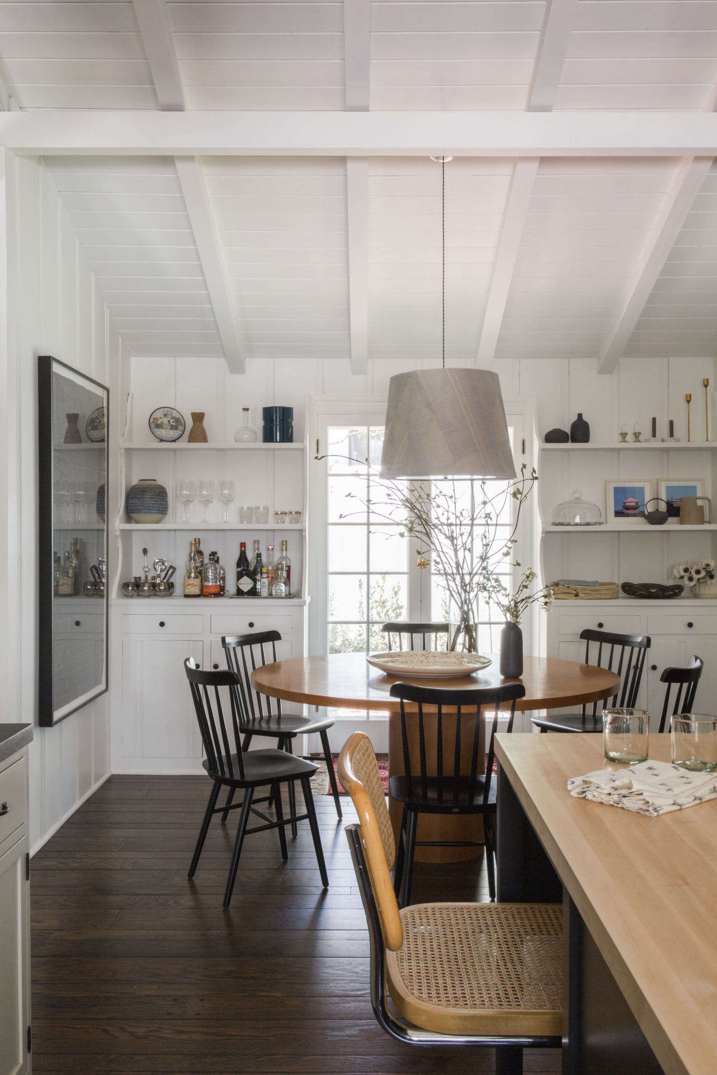 In the dining area: a custom table (saved “from a game room that was being demolished,” Sherwood says) with Salt Chairs and a custom fabric light.