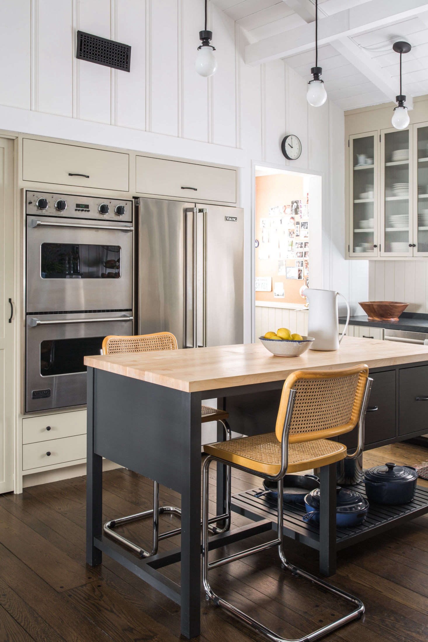 “The goal with the island was for it to feel more like furniture,” Sherwood says; “I had designed a similar island for a client and always liked it.” The cane-seat stools are vintage, found at a flea market.