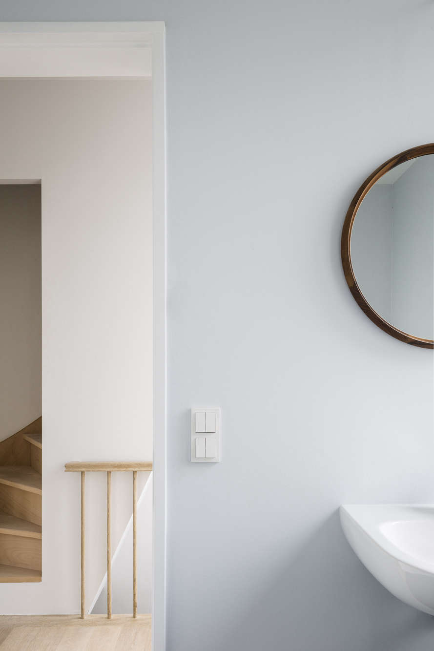 Beside the bedroom, off the hall, is a small bathroom, painted in a proprietary shade of blue from Boss Paints. The sink is by Duravit and the mirror is the client’s own.
