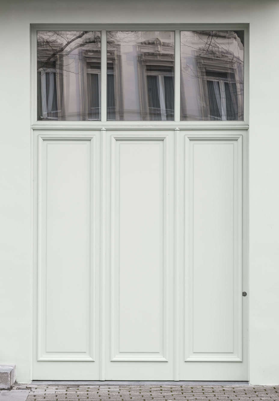 The subtle garage doors. The pale green exterior sets a motif that’s carried throughout the interiors.