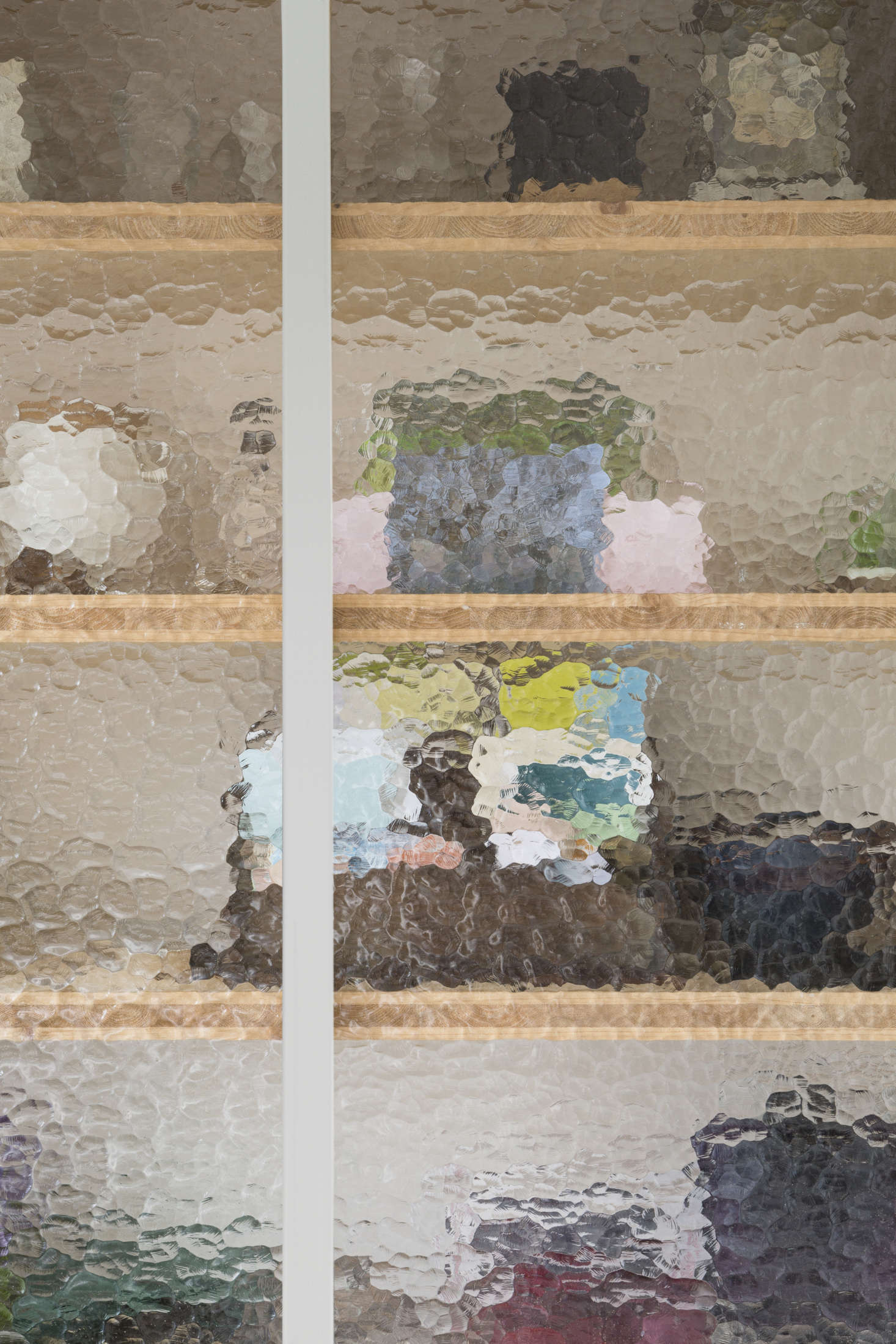 The inset upper cabinets are fitted with dappled glass—”Atlantic” from AGC’s Imagin collection—which lends an almost watercolor quality. “The great thing about this type of glass is that you can see color and sun through the glass,” Seghers says. “It is used very often in entrance doors of old houses.”