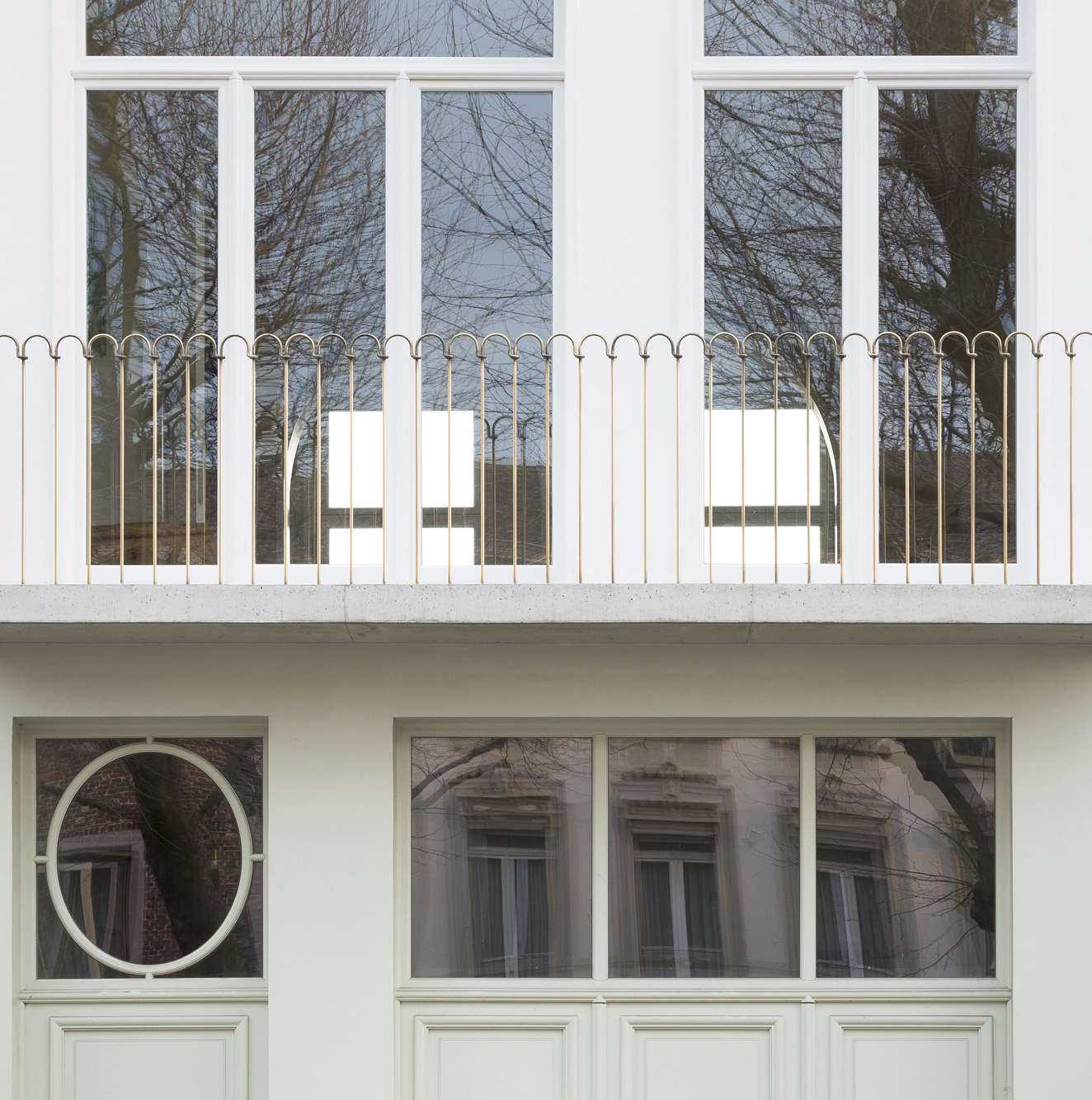 The new facade is two-toned, with a “very light green lacquer paint covering doors and facade, as if in one plinth,” the architects say, adding that the glossiness of the paint makes it easier to maintain and less apt to show dirt. The balcony is made of concrete, poured on-site, with a railing in polished brass which will “get a natural wear by using it,” they say.