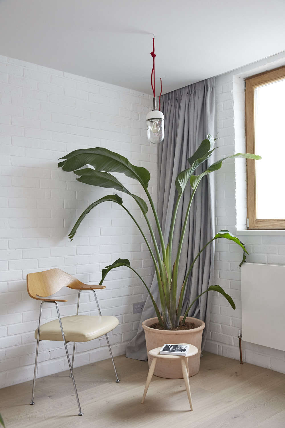 Another trick to make rooms feel bigger: floor-to-ceiling curtains are installed on a track along the ceiling; hidden by a small recess.
