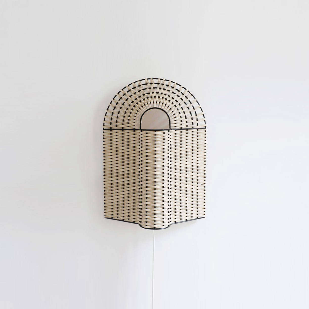 The Paon Medium Lamp in Natural Rattan with black lacquered metal is €335. The lamp can sit on a mantel or table, as shown, or comes with a metal hanging piece to mount on the wall.