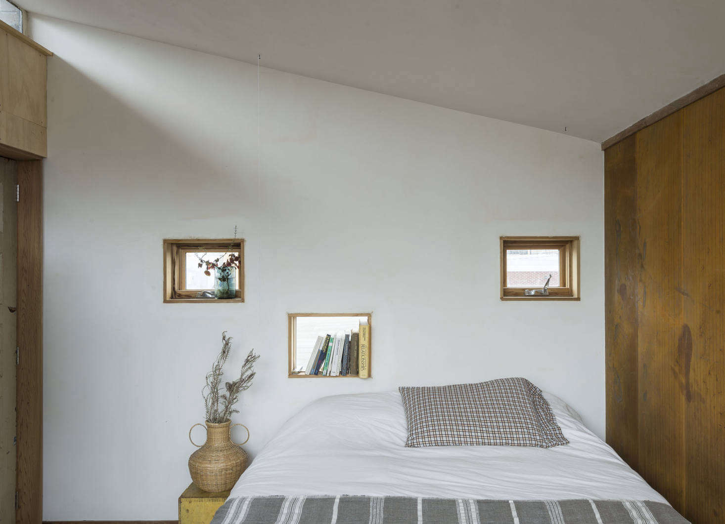 The bedroom wall is made of concrete blocks; the Sierra Pacific windows are slotted into a trio of voids.