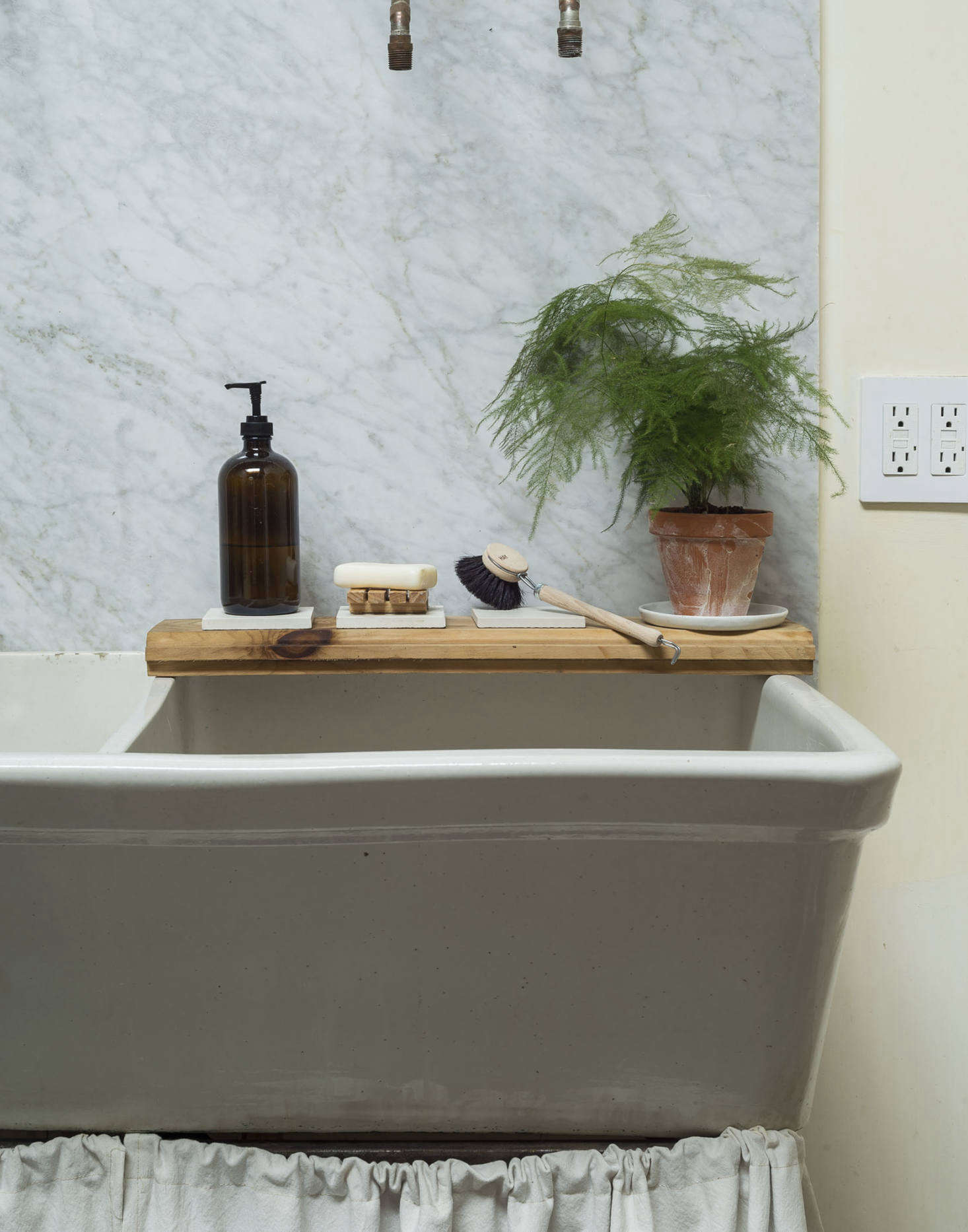 A leftover piece of pine flooring serves as a ledge for sink essentials.