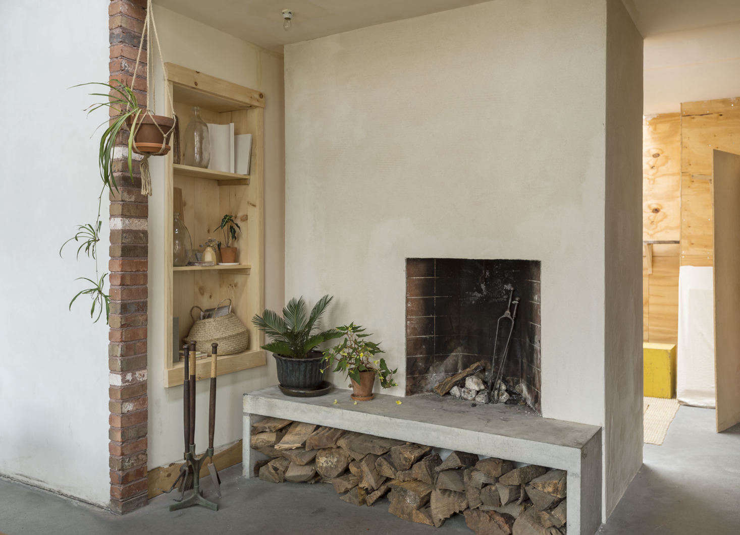 The double-sided Rumford fireplace is made of concrete masonry block. “We designed and cast in place the concrete hearth, which also acts as a bench,” Bretaigne says. “We have a lot of fires in the winter; it’s like 18th century Russia in here.”