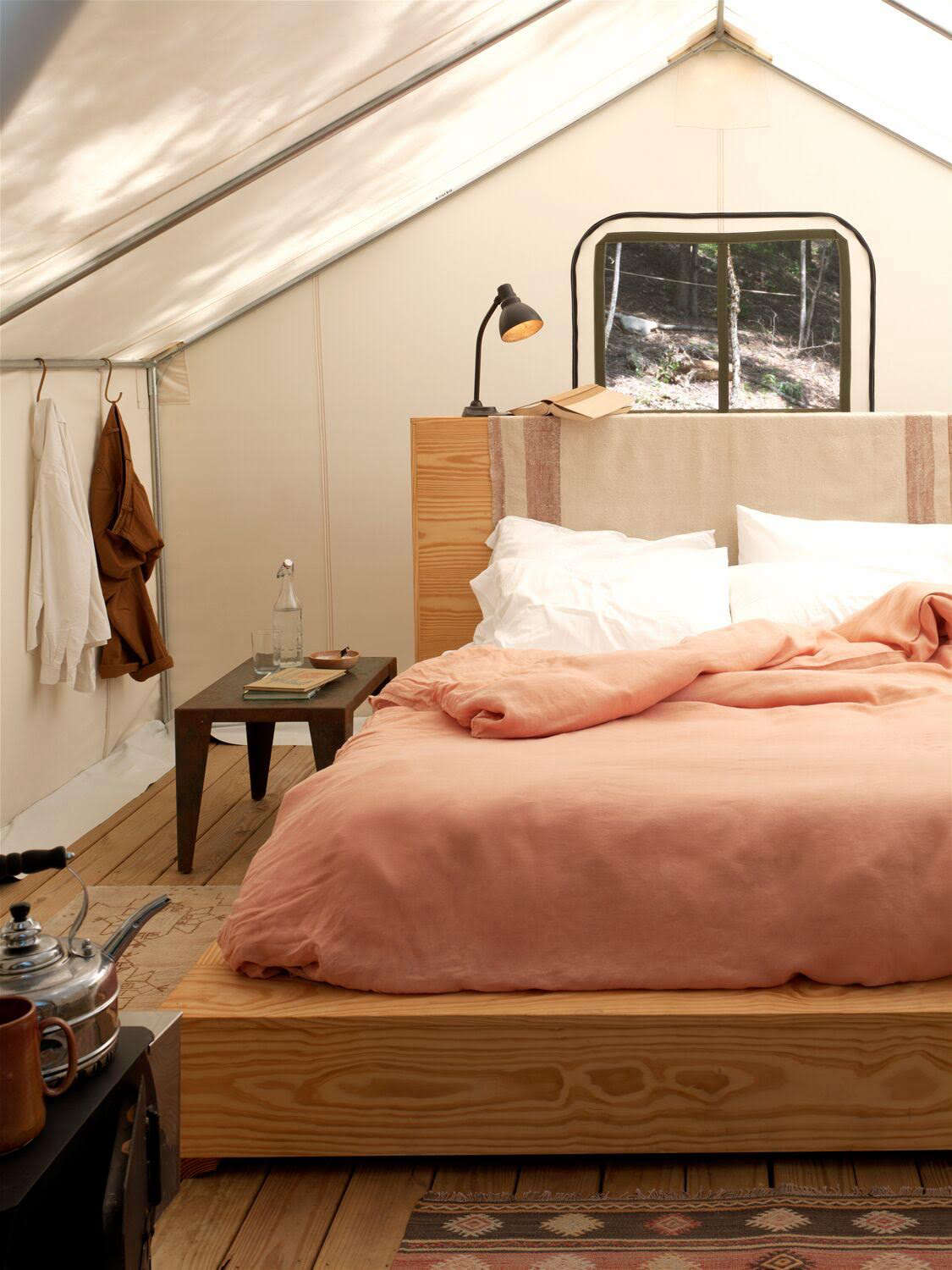 Jesse and the Aesthetic Movement team furnished the tents with custom pine platform beds (the high headboards double as shelving on the reverse side) and wood-burning stoves with kettles for making tea or filling hot water bottles. S hooks on the tent poles serve as clothes hooks. At check-in, guests are given a welcome kit that comes with palo santo incense, an annotated list of local attractions (from hikes and ponds to a cidery and auction house), plus instructions for keeping away bears.