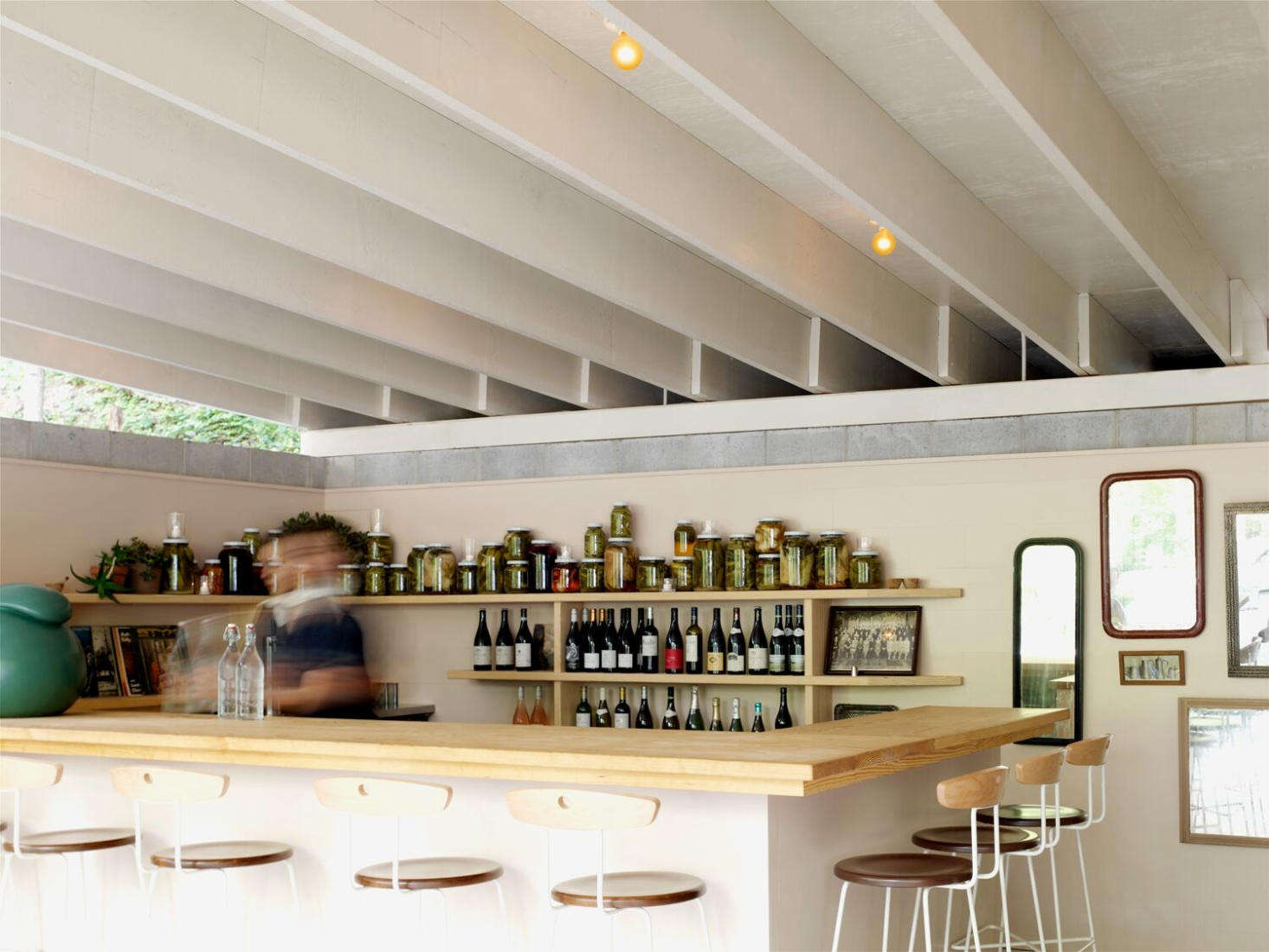 Anna Stools by Lostine surround the bar. The lineup of jars in the background are pickled vegetables that are served as bar snacks.