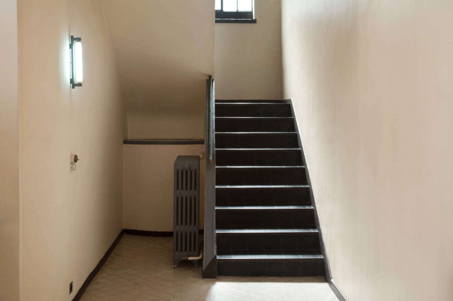 The foyer walls are painted Ivory and the staircase and radiator are Dark Gray. 