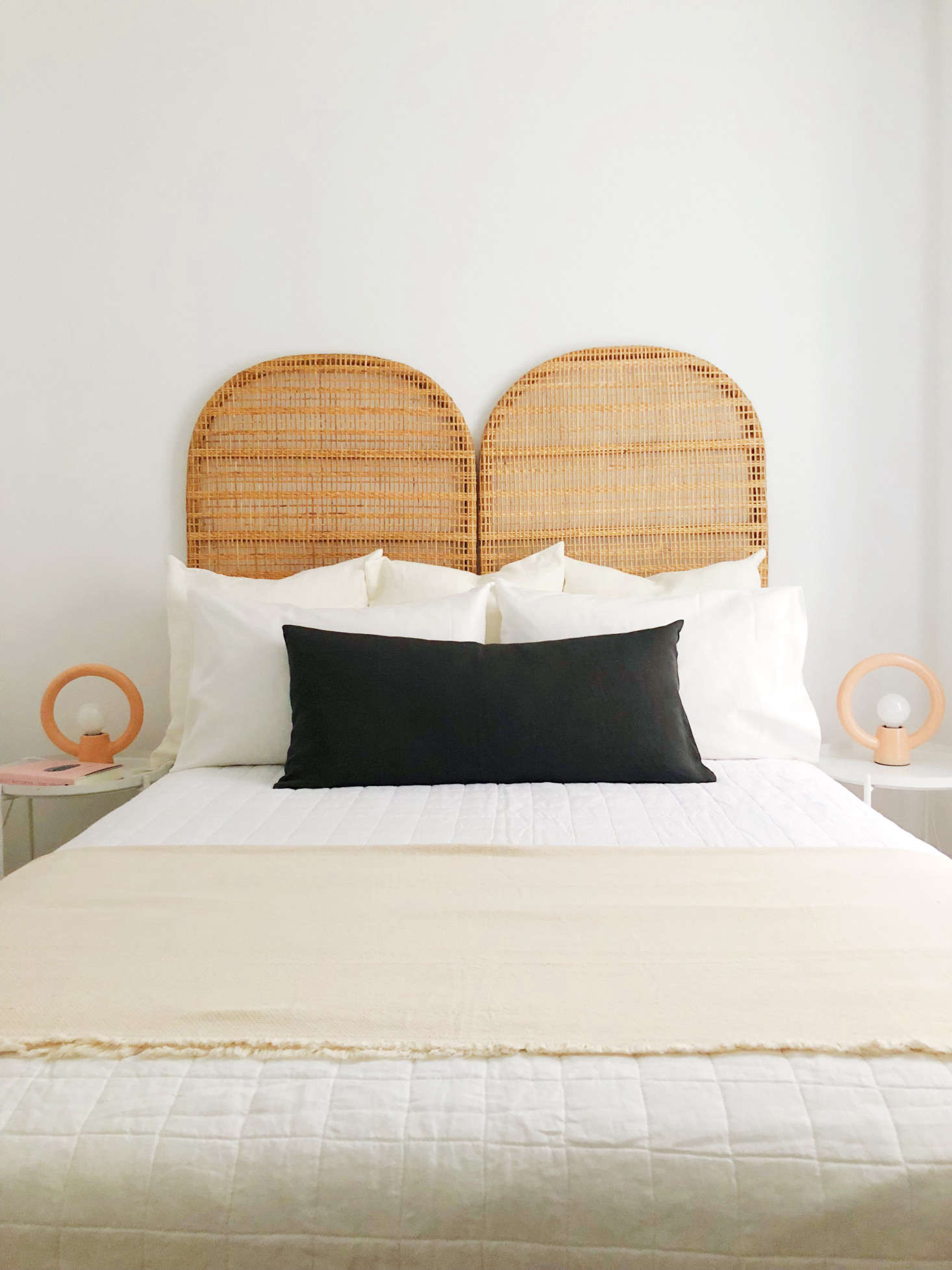 The Hoveys furnished a bedroom in the same apartment with an Ikea limited-edition rattan headboard and Urban Outfitters Ayo Ceramic Table Lamps—both since discontinued. The Belgian Linen Quilt, $249, is from West Elm and the dark gray Linon Pillow, $54.95, is from CB2.