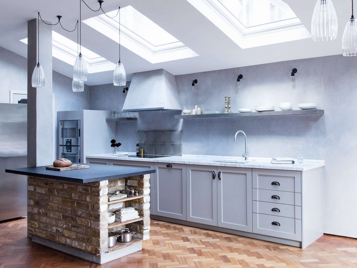 A clever use of interior brick: A kitchen island that references an indoor fireplace or pizza oven.