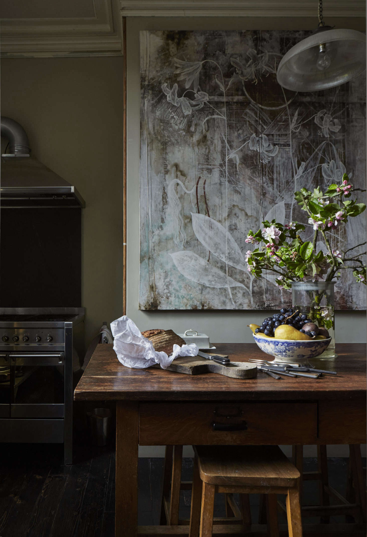 The kitchen has an industrial cooker. On close inspection the dining table is inset with two coins: David discovered that a Queen Victoria one penny and Queen Elizabeth sixpenny was a perfect fit, to plug the Bunsen burner holes.