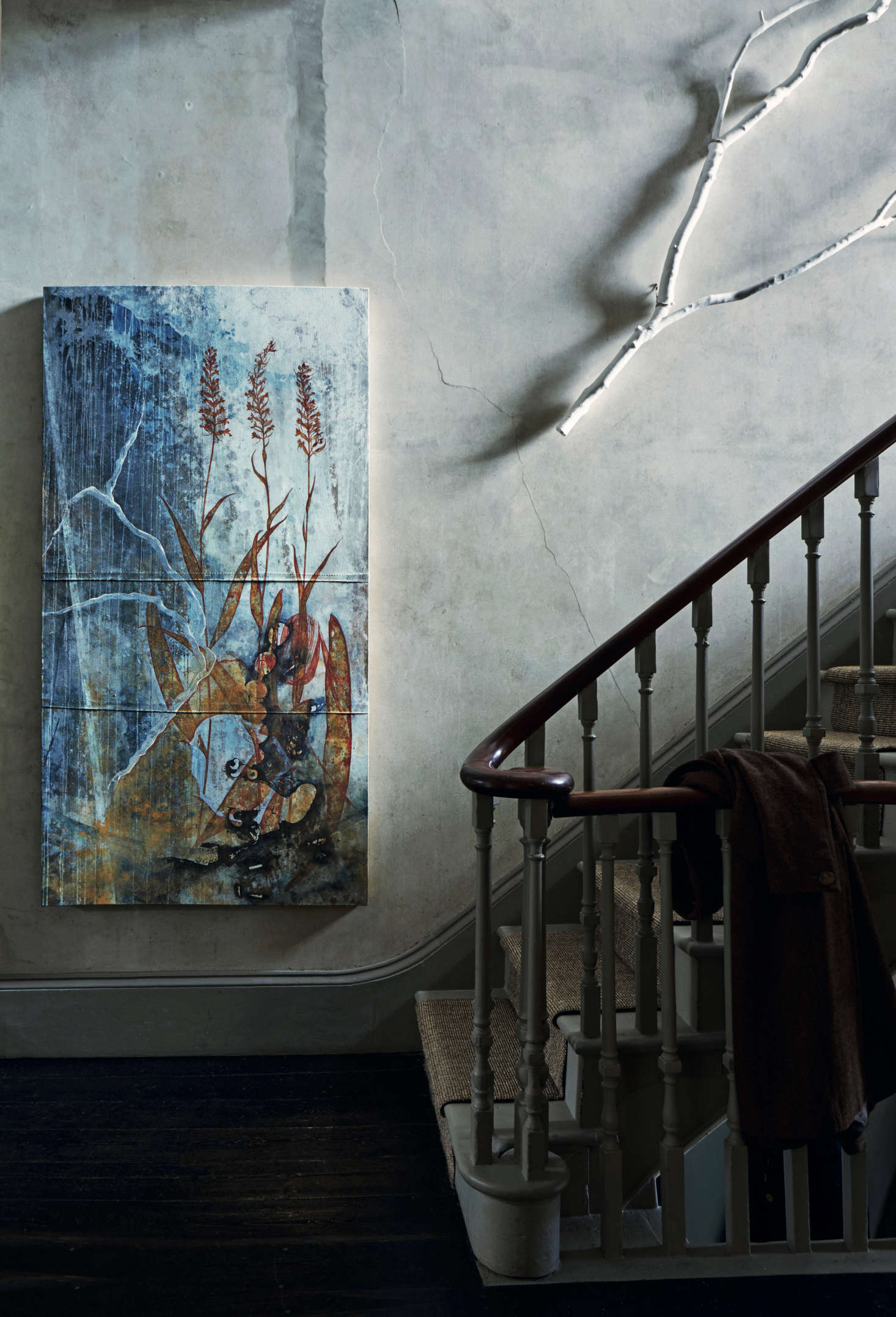 One of David’s paintings and a whitewashed branch hang against bare plaster walls in the entry stairwell. David and Anita live several months a year on the Mani Peninsula of Southern Greece, and David says his work is inspired by the area’s natural landscape and its church wall paintings “richly patinated in their various states of decay.”