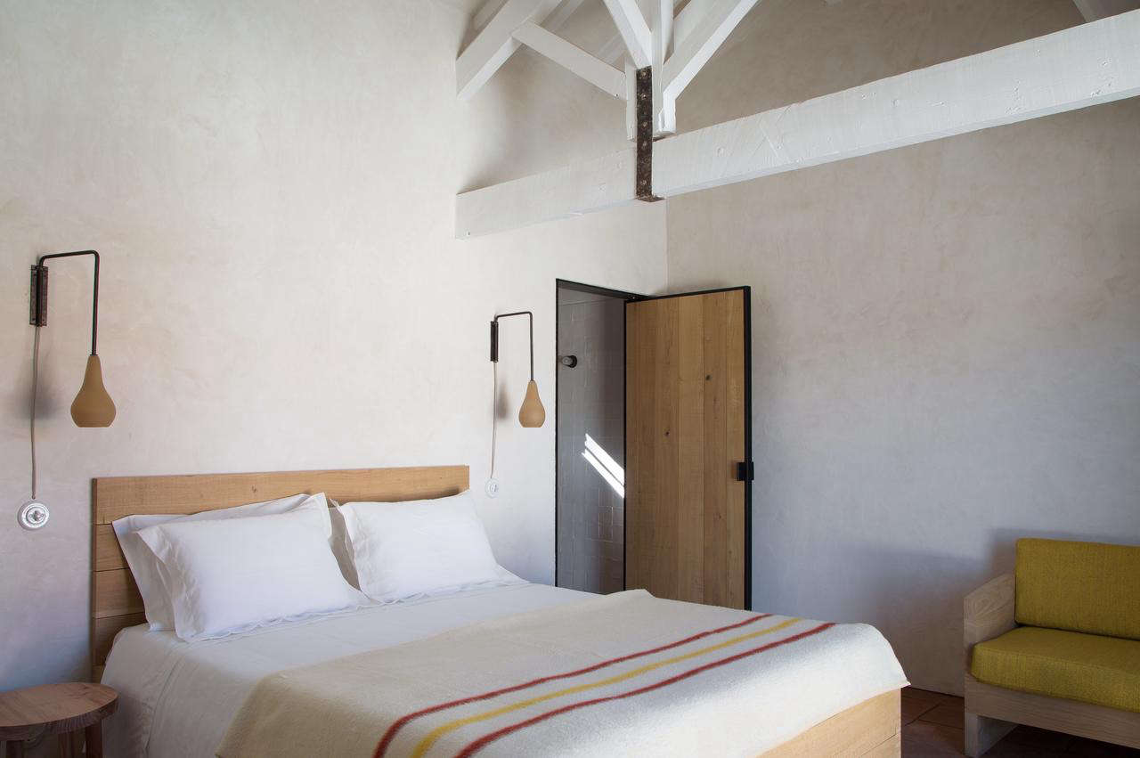 Another guest bedroom, with embroidered bed linens and subtle dashes of color.