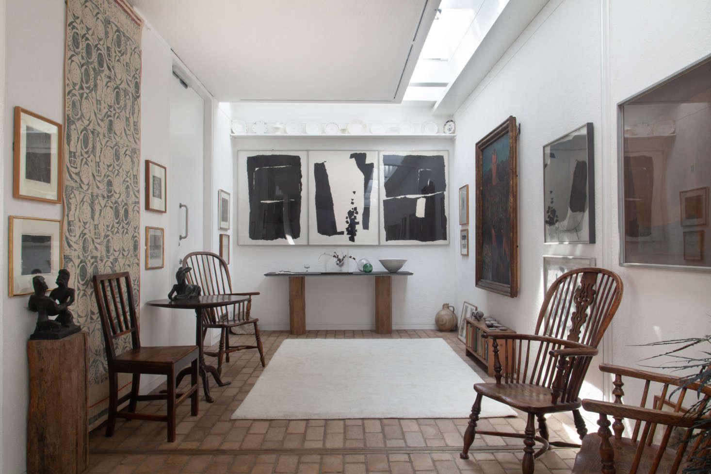 On the back console table, made of two pieces of wood and a slate top, the Lucie Rie Conical Bowl (far right) and John Clegg