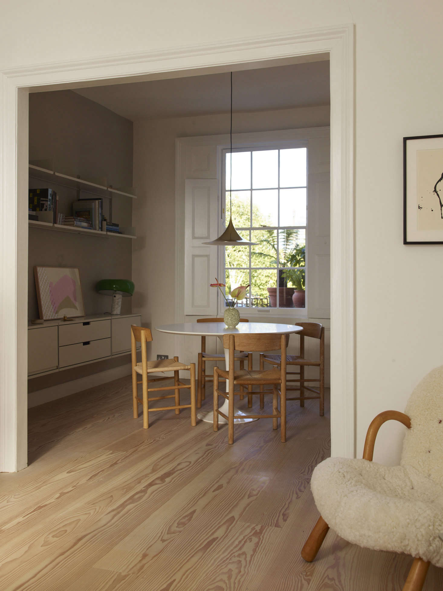 The dining room, with a Vitsoe wall-mounted shelving unit and a vintage Gubi pendant from Denmark.