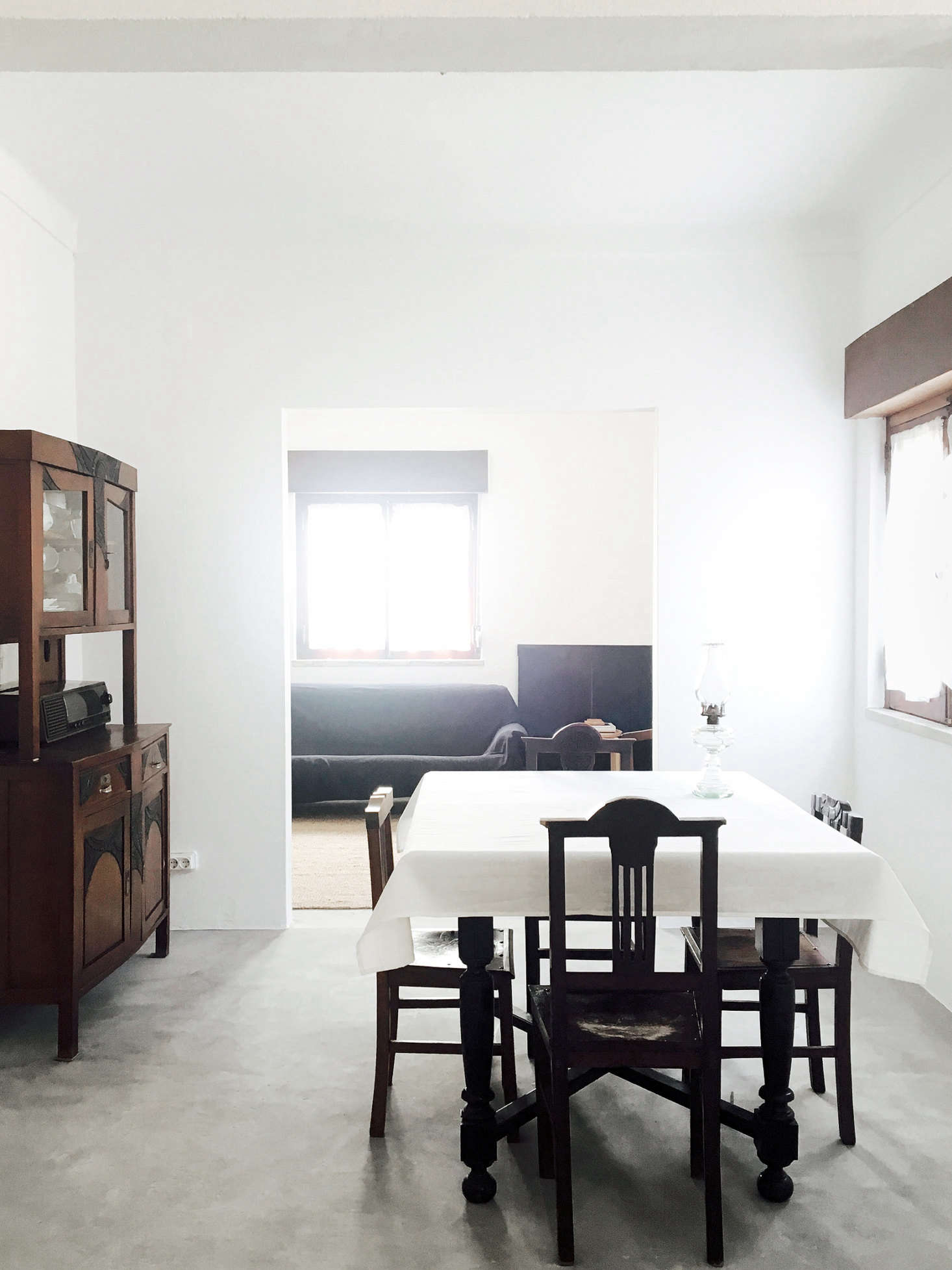 The dining area and living room beyond. “Doors and windows were preserved with their original varnish finishing and hardware from the 1970s,” Bento says. All of the furniture was existing in the house, including the wood hutch and dining chairs, both “believed to be from the 1960s,” Bento says.