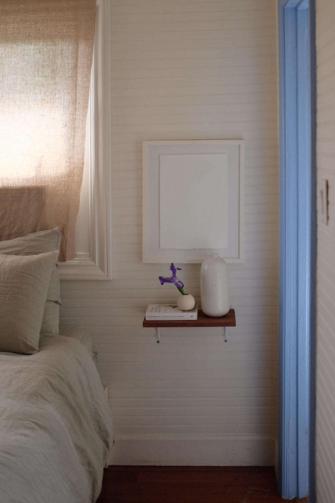To save space, Alex and Jodi used small shelves in place of nightstands. The bed frame is from Ikea.